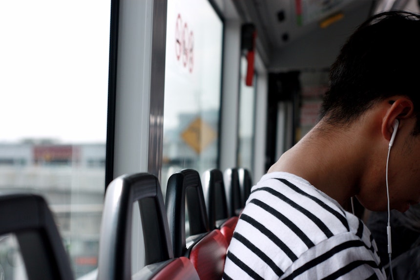 Person on bus with earphones in.