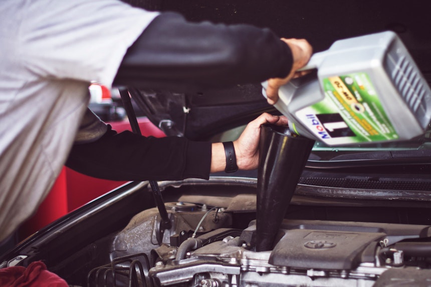 Mechanic changing the oil of a car.