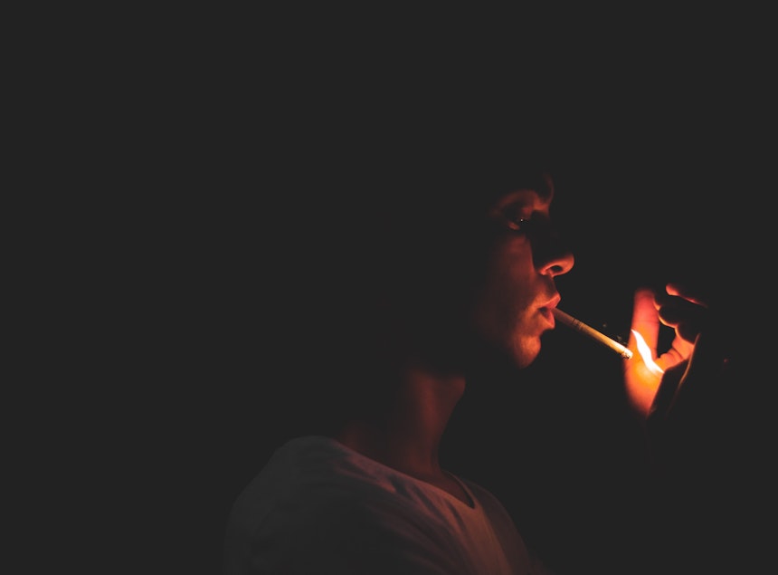 Boy lighting a cigarette.